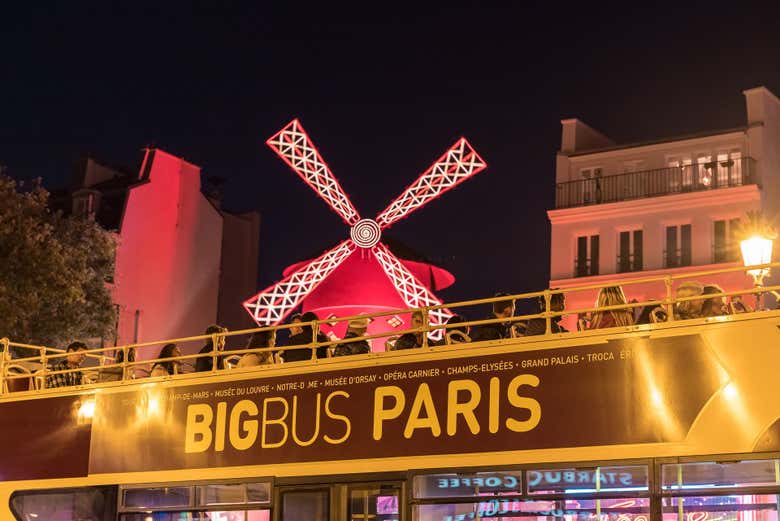 El autobús turístico de París ante el famoso Moulin Rouge