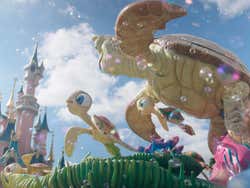 Carroza con dos tortugas expulsando burbujas de jabón frente al castillo de Disneyland París